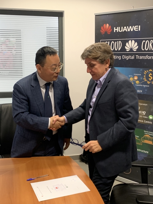 Representatives from Huawei and education management organization SABIS shake hands after agreeing an IT-focused alliance