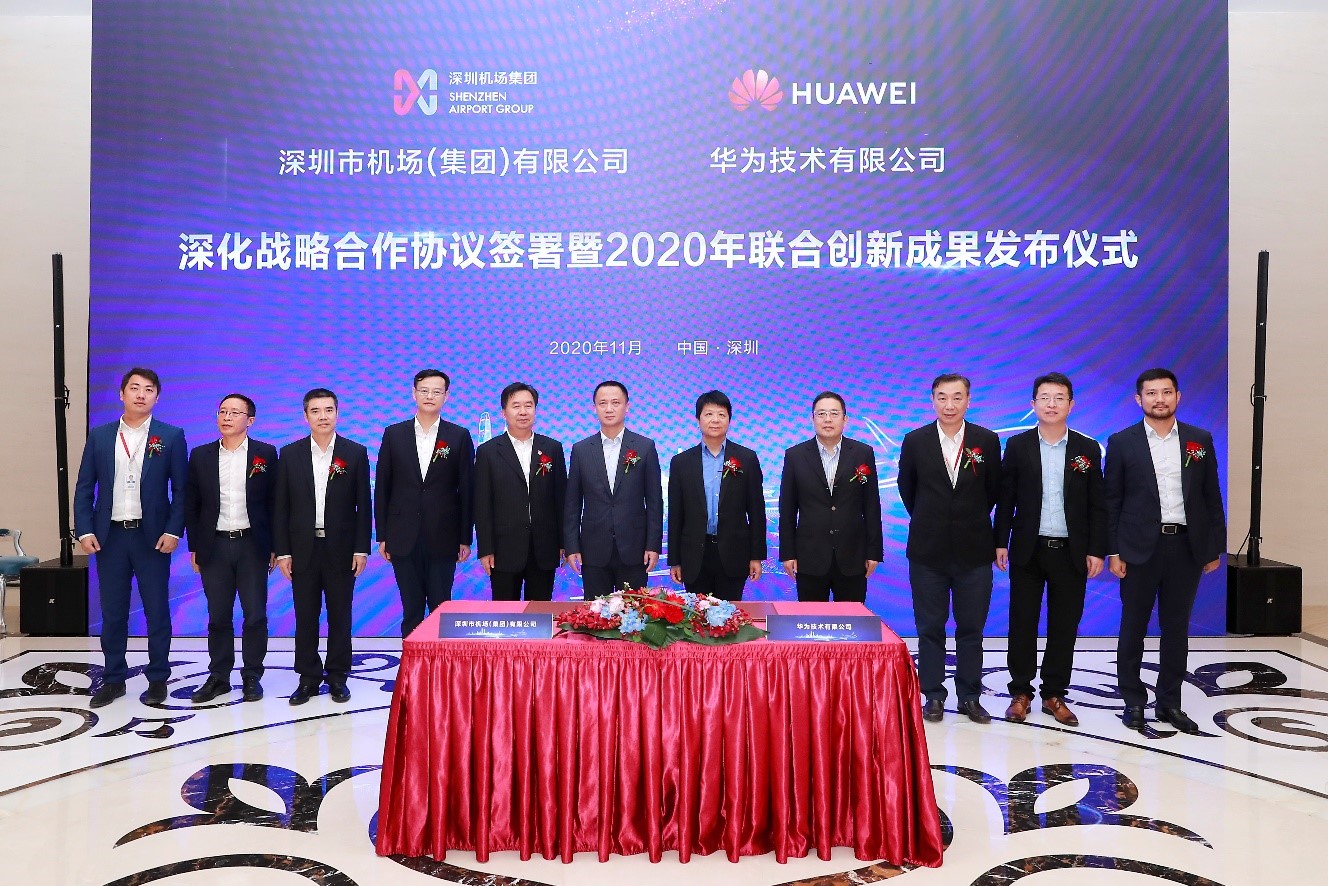 11 executives from Shenzhen Airport and Huawei pose for a photograph after the signing a strategic cooperation agreement