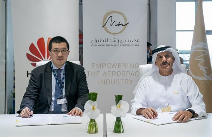 Jerry Liu, Huawei UAE CEO, and H.E. Khalifa Al Zaffin, Exec. Chairman of Dubai South, sitting behind a desk, signing an MOU