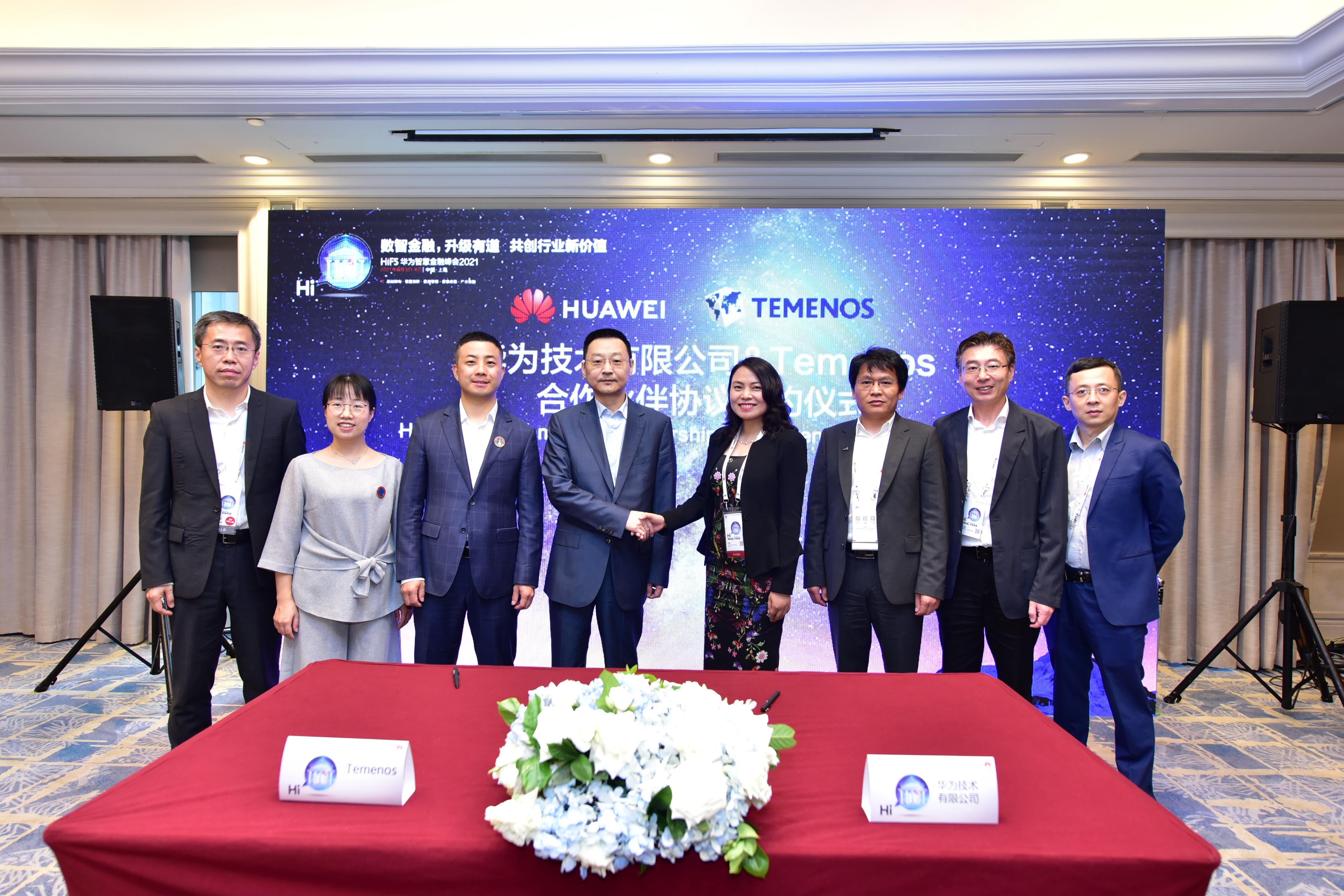 Executives from Huawei and Temenos shake hands to symbolize their technology partnership agreement