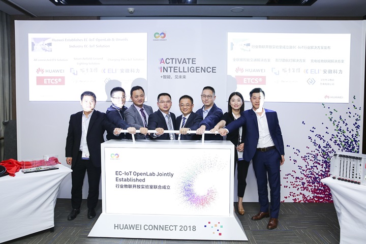 Eight Huawei executives with their hands on a lever at the launch of the Edge Computing–Internet of Things (EC-IoT) Solution